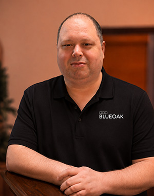 Man in black BlueOak polo shirt for team headshot